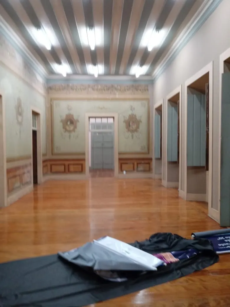 Sequência de salas com paredes em verde-claro e pinturas decorativas restauradas