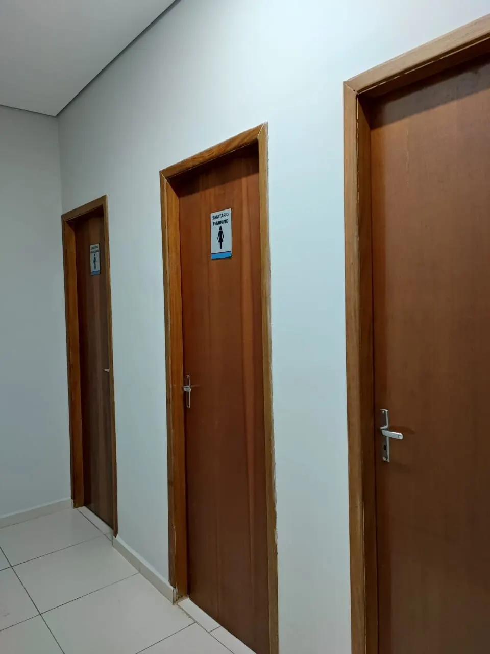 Portas de madeira em corredor com paredes pintadas