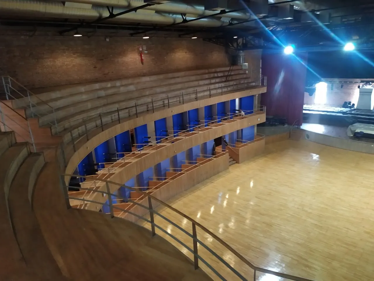Galerias e palco iluminado vistos do mezanino durante a pintura