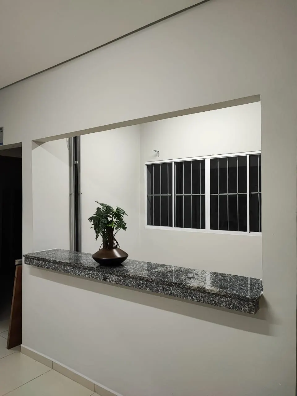 Balcão de atendimento com tampo de granito e paredes brancas