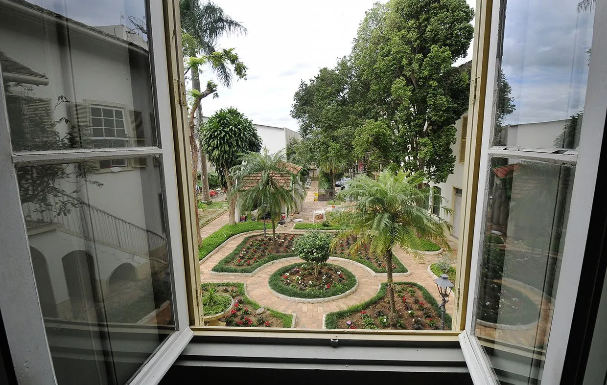 Vista do jardim pela janela de madeira restaurada